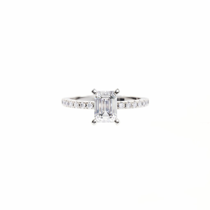Diamond ring with a rectangular center stone on a white background