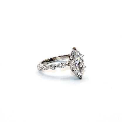 Diamond ring with a pear-shaped center stone on a white background