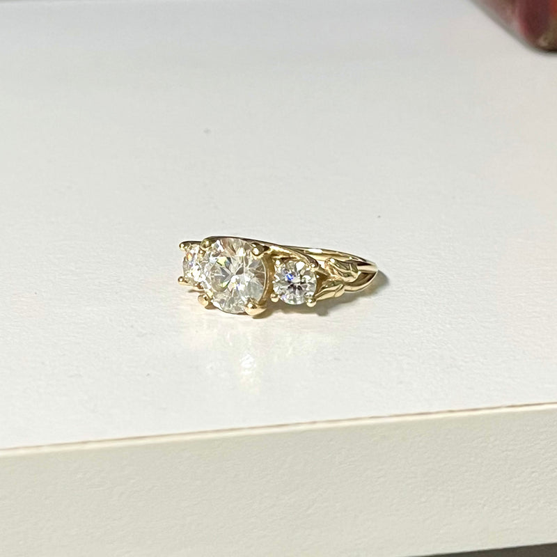 Gold ring with two diamonds on a white surface