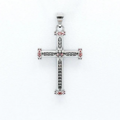 Silver cross pendant with pink gemstones on a white background