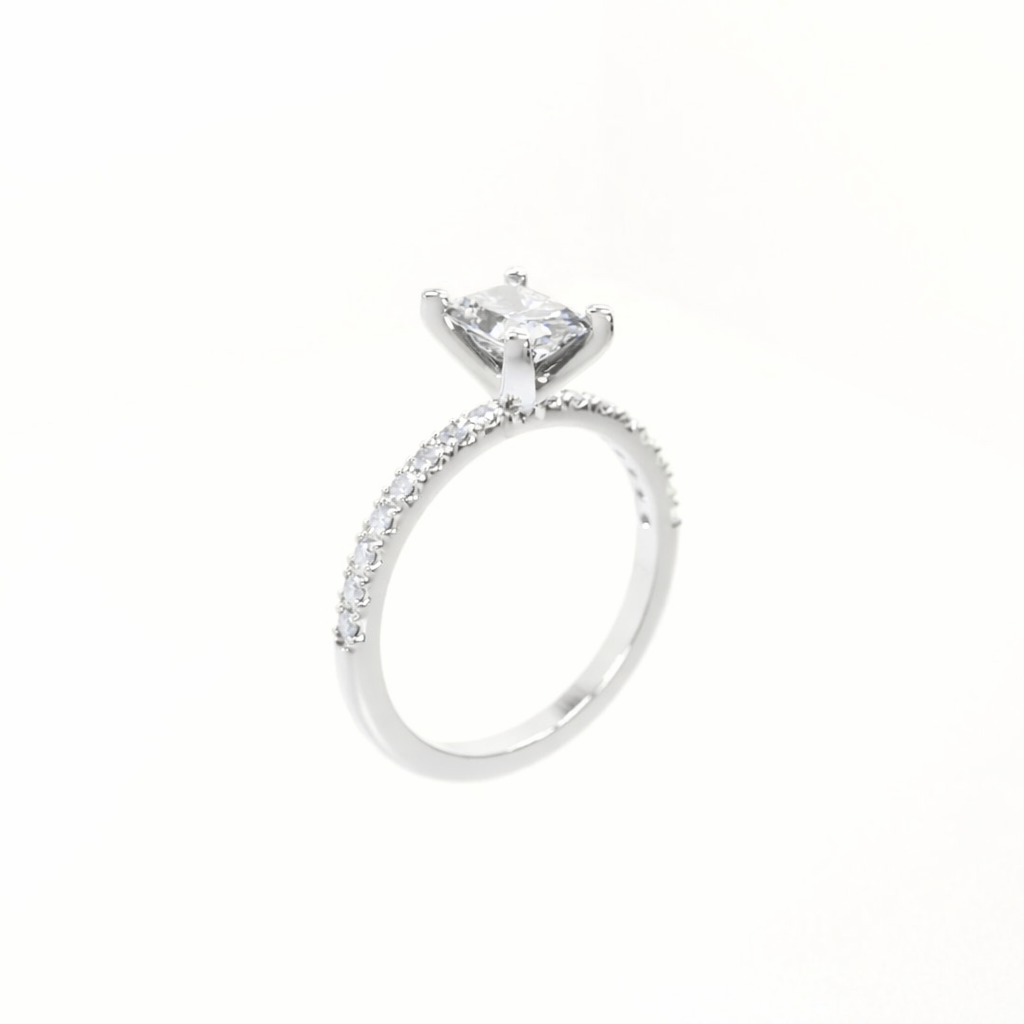 Silver ring with a large central diamond and smaller diamonds on the band against a white background