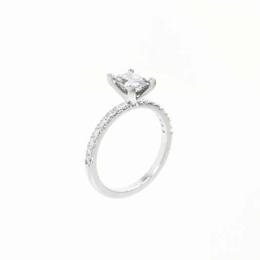 Silver ring with a large central diamond and smaller diamonds on the band against a white background