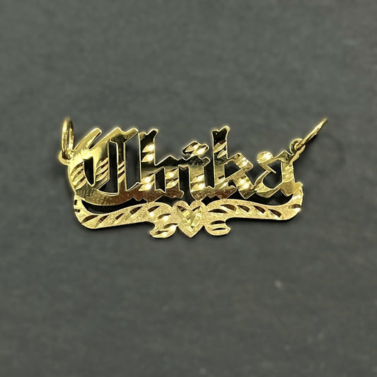Gold pendant with 'Chika' inscription on a gray background