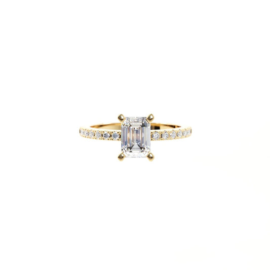 Gold ring with a large diamond and smaller diamonds on the band against a white background