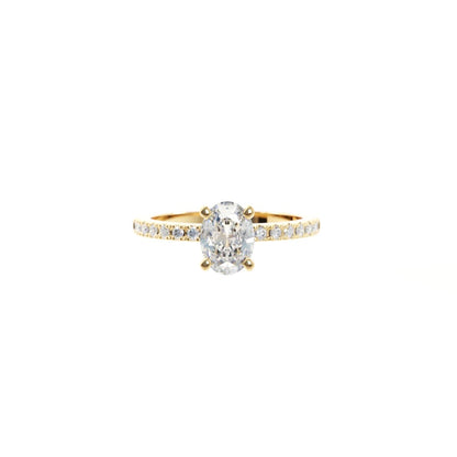 Gold ring with a large diamond and smaller diamonds on the band against a white background