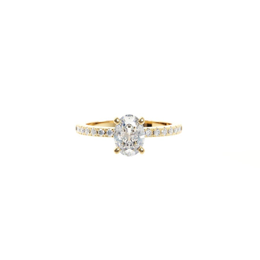 Gold ring with a large diamond and smaller diamonds on the band against a white background
