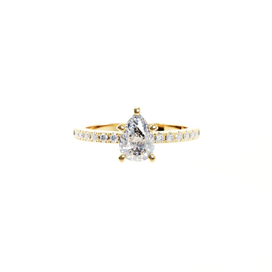 Gold ring with a pear-shaped diamond on a white background