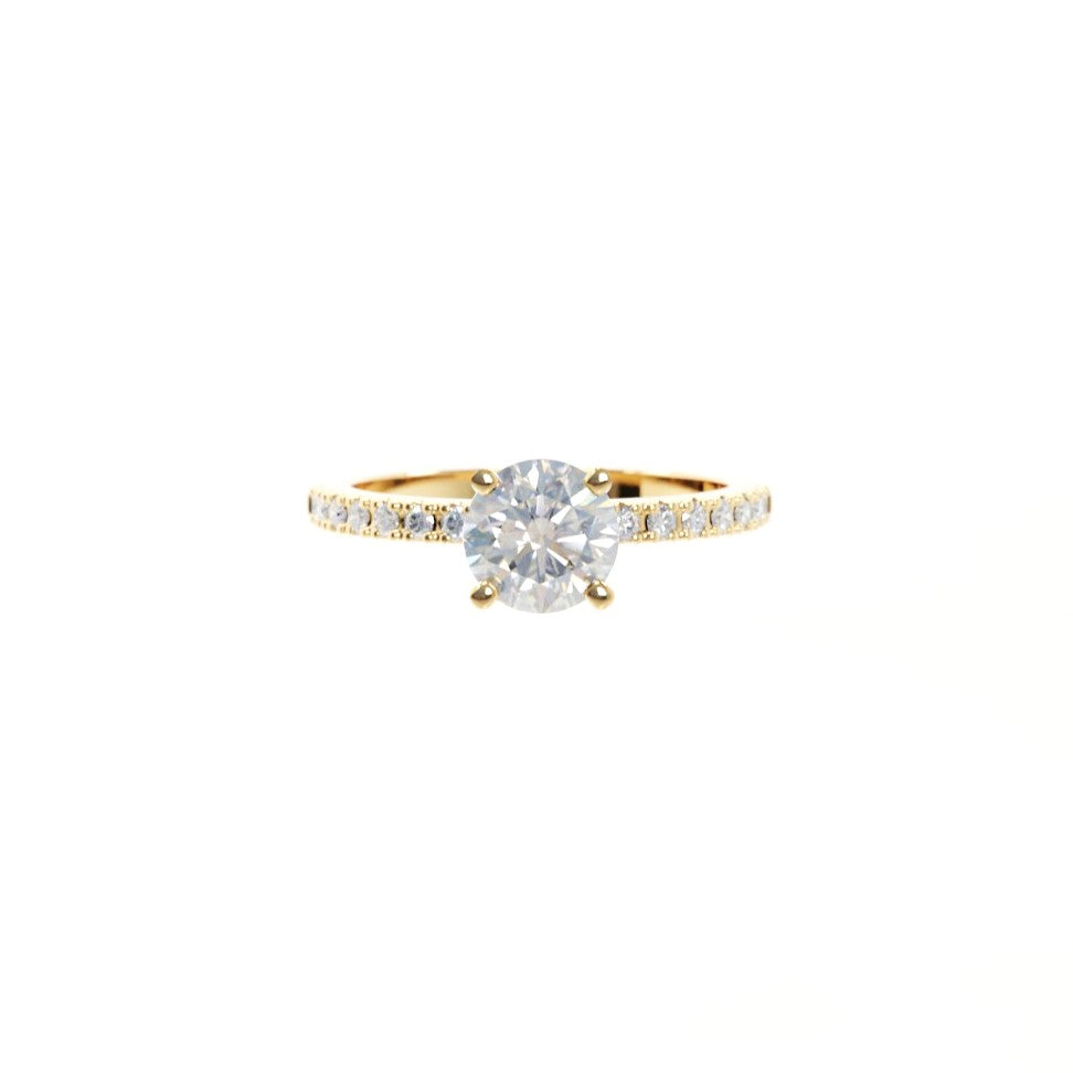 Gold ring with a large diamond and smaller diamonds on the band against a white background