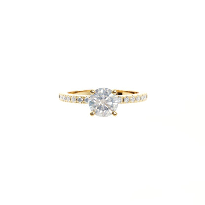 Gold ring with a large diamond and smaller diamonds on the band against a white background