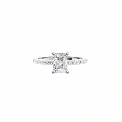Diamond ring with a central princess-cut diamond and smaller diamonds on the band against a white background