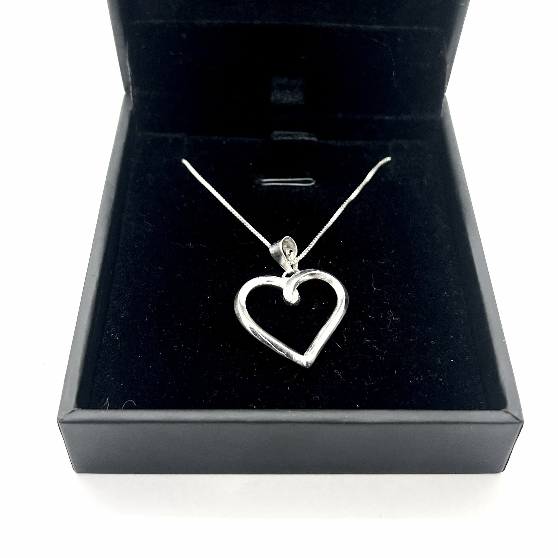 Silver heart-shaped pendant necklace in a black jewelry box