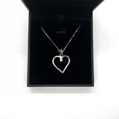 Silver heart-shaped necklace in a black jewelry box on a white background