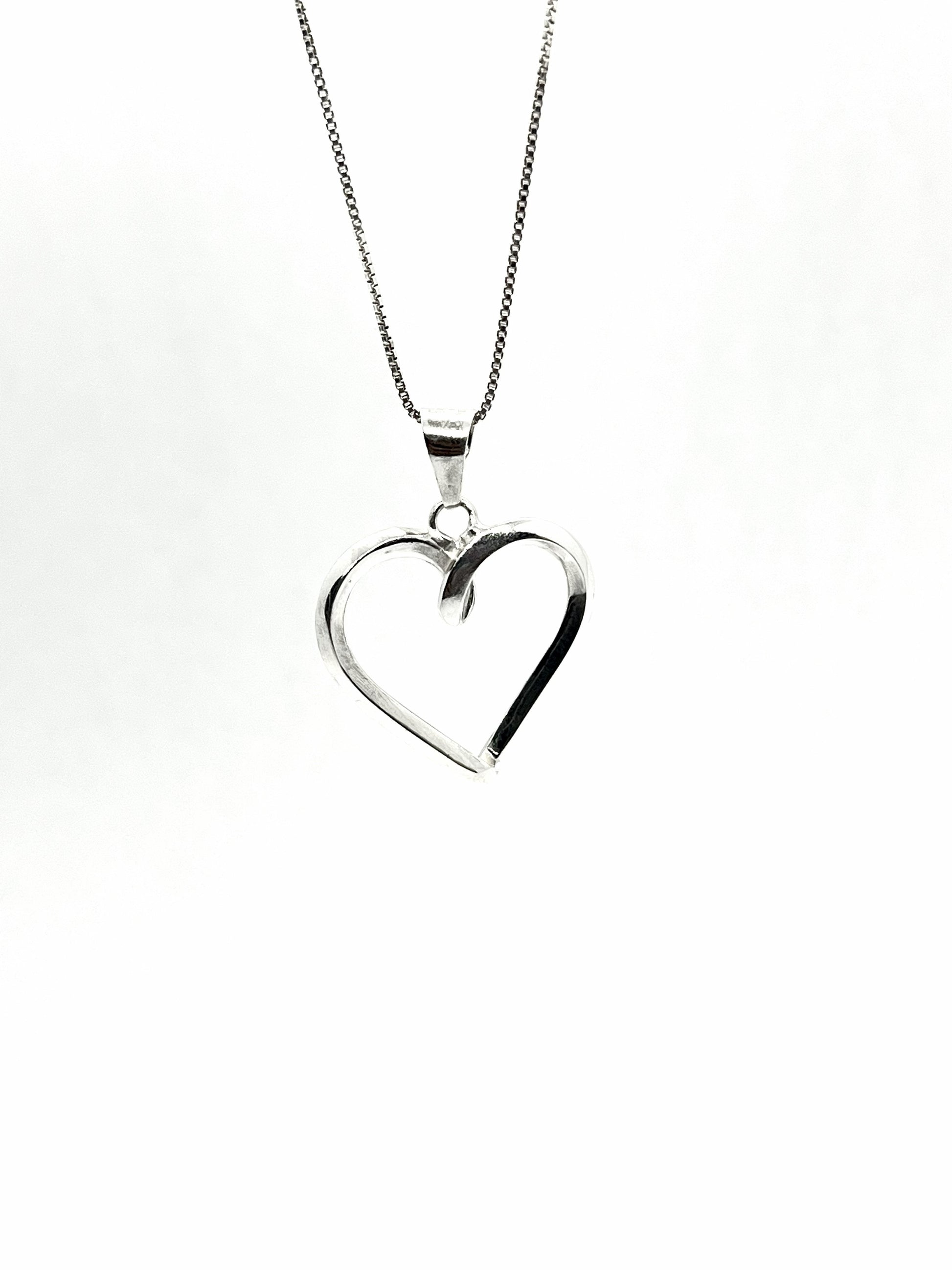 Silver heart-shaped pendant on a chain against a white background