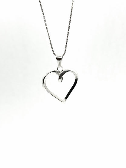 Silver heart-shaped pendant on a chain against a white background