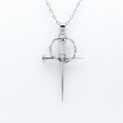 A sterling silver pendant featuring a crown of thorns design above a vertical nail, attached to a silver chain.