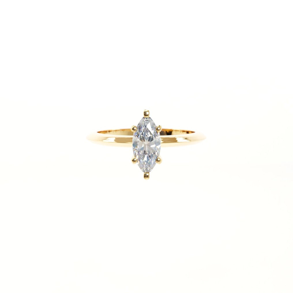 Gold ring with a marquise-shaped diamond on a white background