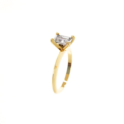 Gold ring with a rectangular diamond on a white background