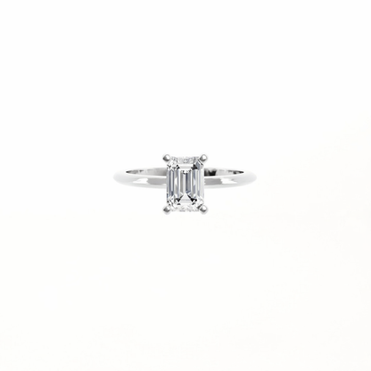 Diamond ring with emerald-cut stone on a white background
