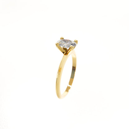 Gold ring with a clear gemstone on a white background