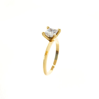 Gold ring with a clear gemstone on a white background