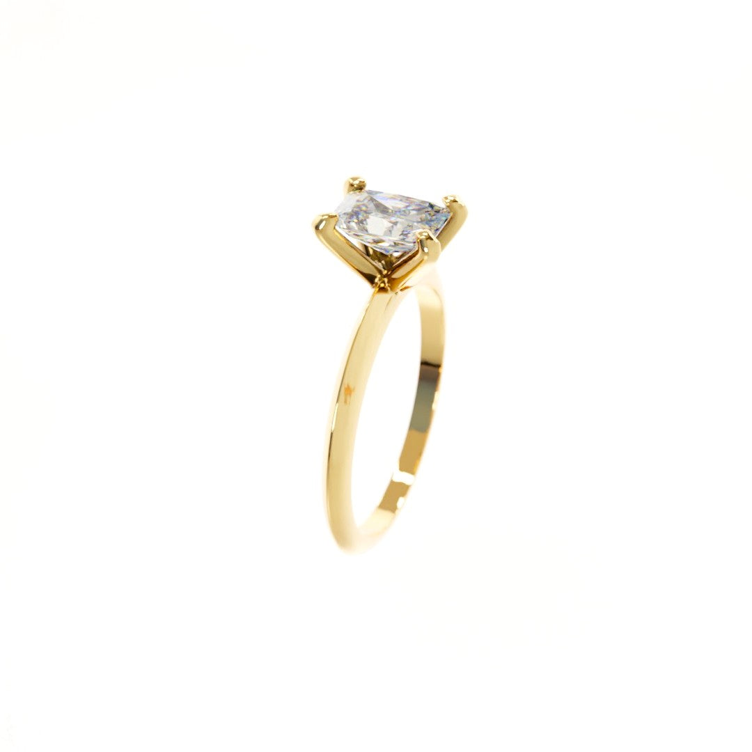 Gold ring with a clear gemstone on a white background